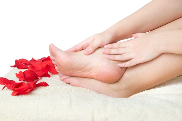 Foot care. Beautiful female legs and rose petals