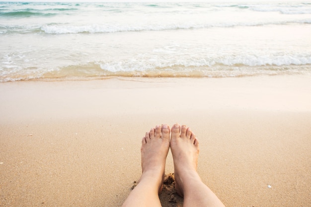 foot of human on sand and soft wave on the sea. 