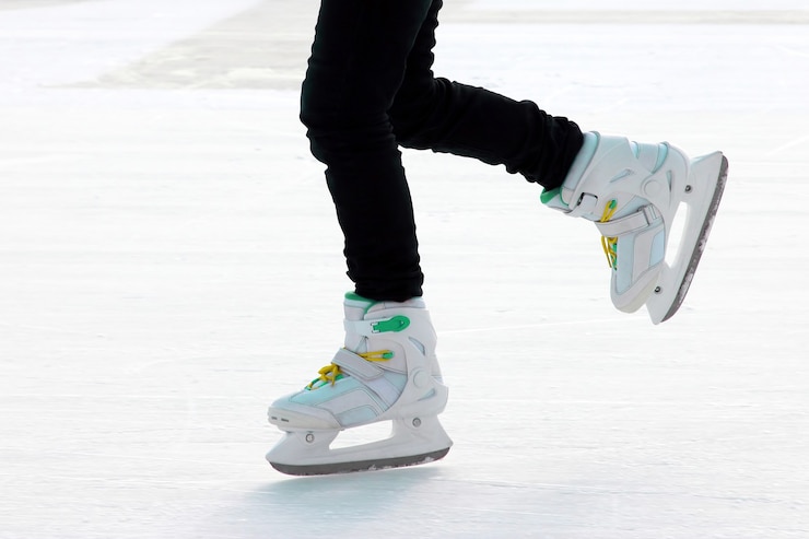 Photo アイススケートリンクの足のアイススケートの人。スポーツとエンターテインメント。休息と冬休み。