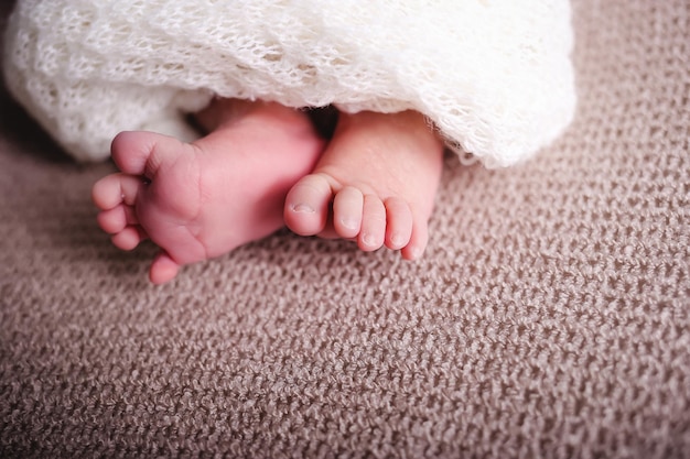 Photo foot newborn baby girl posing and smiling