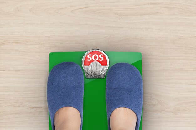 Foot standing on weight scales with text sos