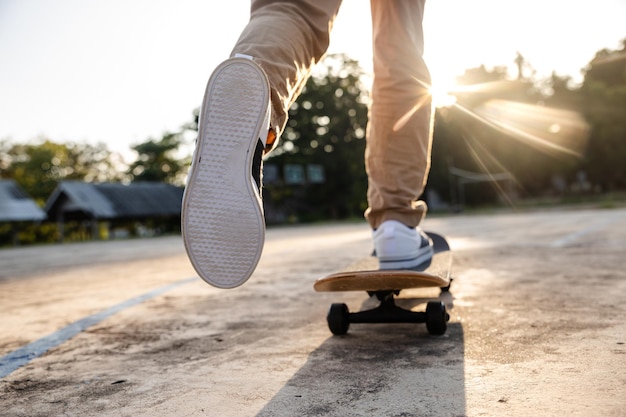 Foot of teenager playing skateboard on cement ground, extreme sport and outdoor activity.