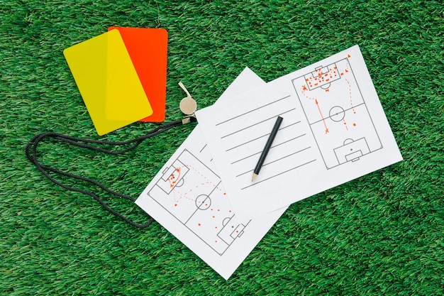 Photo football background on grass with tactic paper and cards