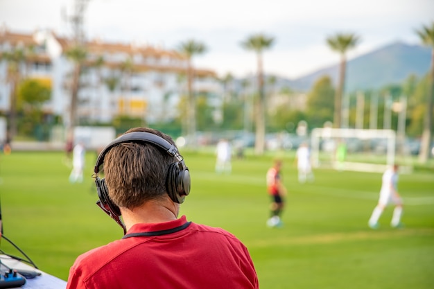 サッカーの解説者は、テレビとラジオで試合をライブで説明します。コピースペース
