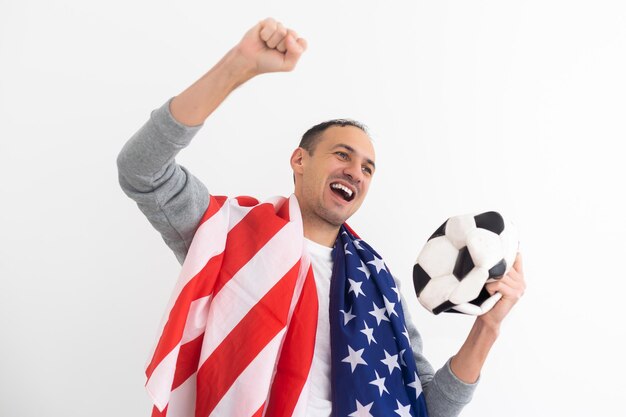 Football fan watching sport game supporting team raising hands after winning the competition, eating popcorn. Excited man celebrating good scoring of championship in living room drinking beer. High qu