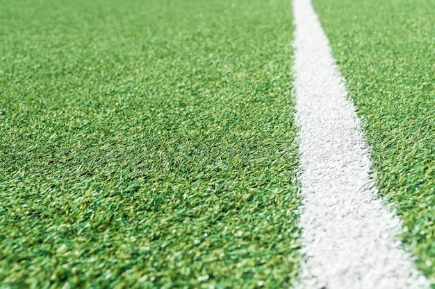 Football field with artificial grass and a white line on the side, stretching into the distance