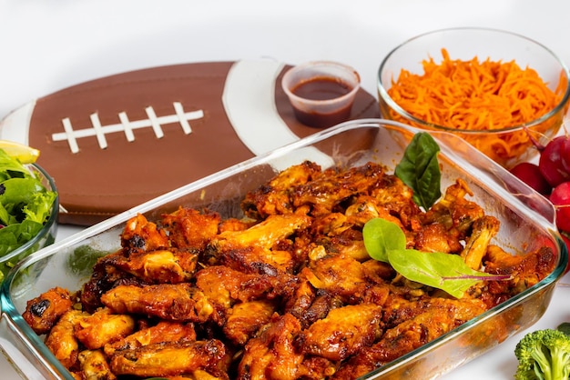 For football game party wings are served with dip sauce and salad