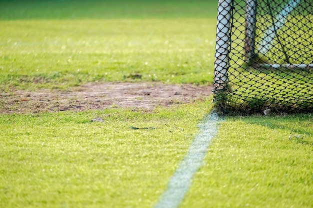 背景がぼやけているフィールドでのサッカーゴールネット。