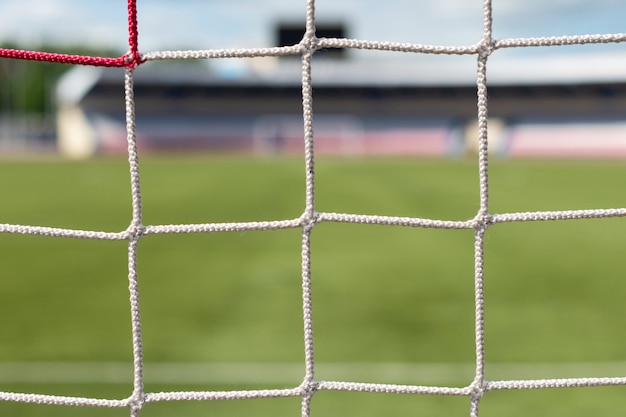 Football goals at stadium. Soccer field background. White and red nets color.