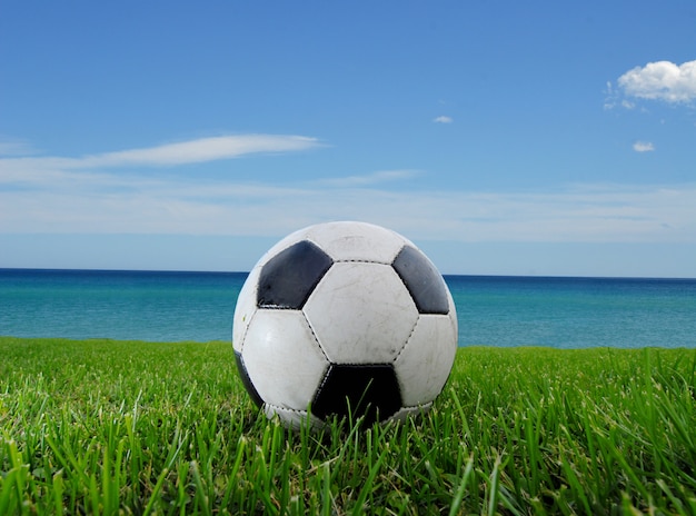 Football on the grass in the summer and the sea