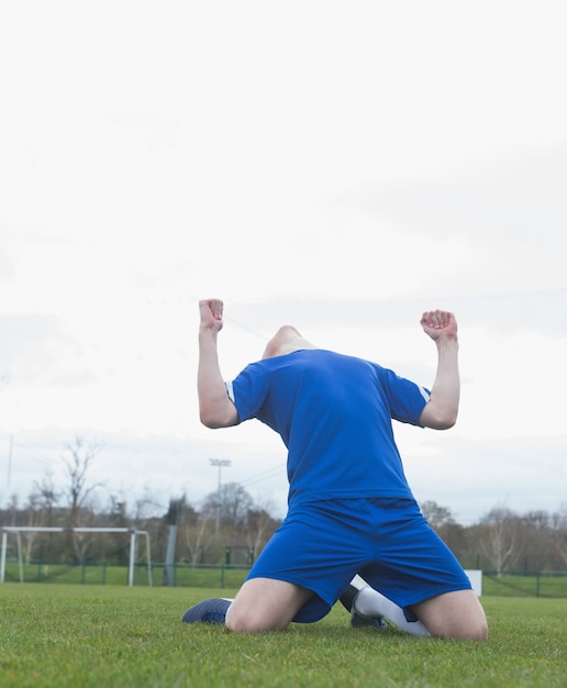 Foto giocatore di football americano in blu che celebra una vittoria