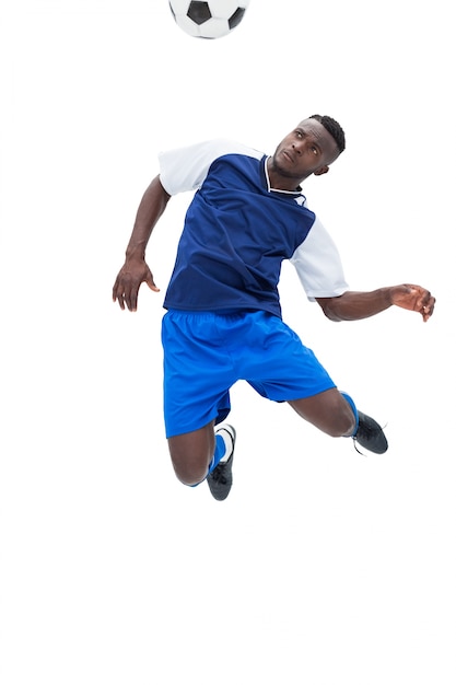 Football player in blue heading ball