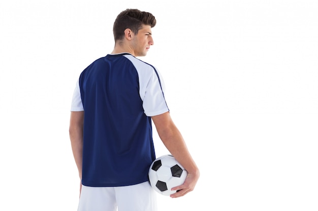 Football player in blue jersey holding ball