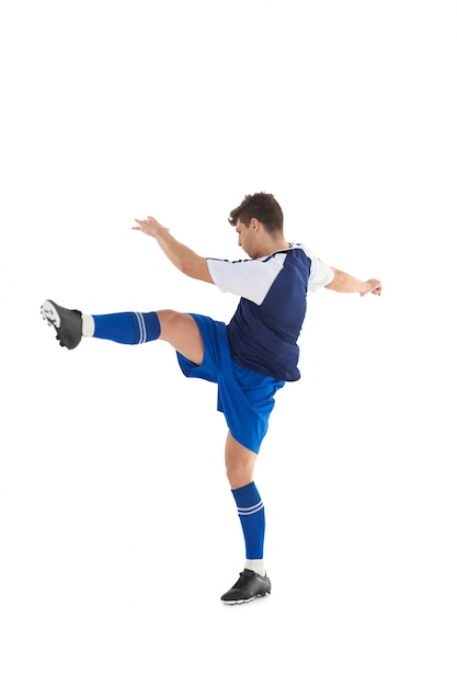 Football player in blue jersey kicking