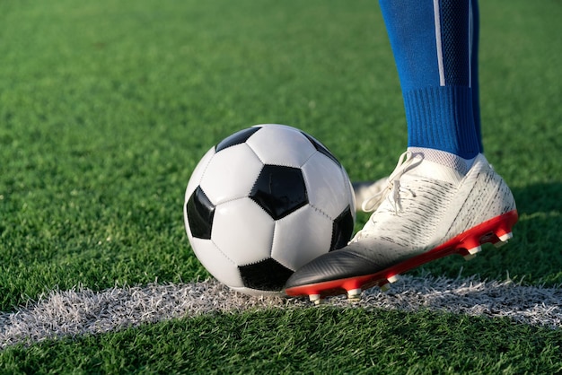 Футболист установил футбольный мяч на траве в точке штрафного удара перед ударом или ударом, чтобы выиграть счет в футбольном матче международной лиги