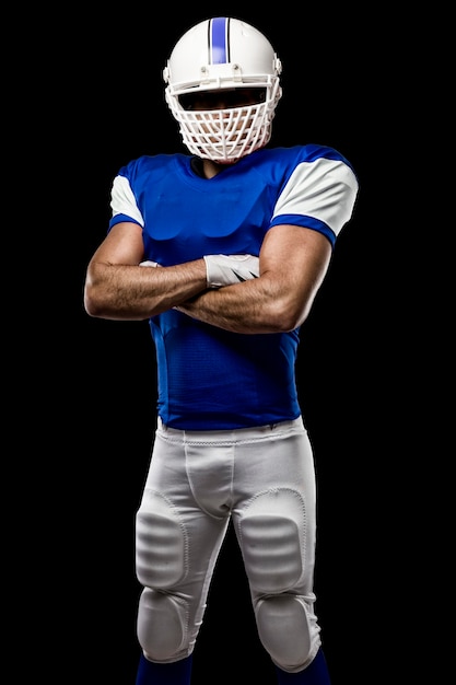 Football Player with a blue uniform on a black wall