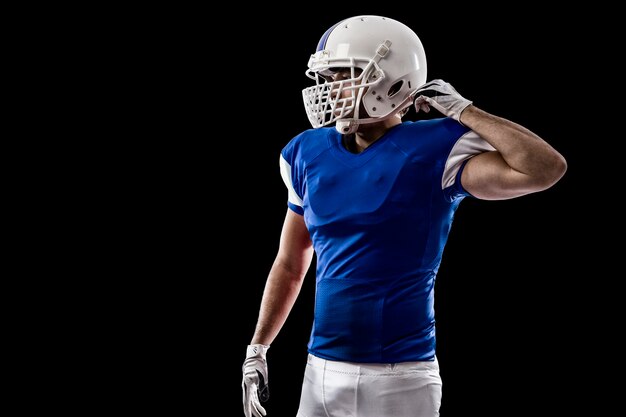 Photo football player with a blue uniform on a black wall