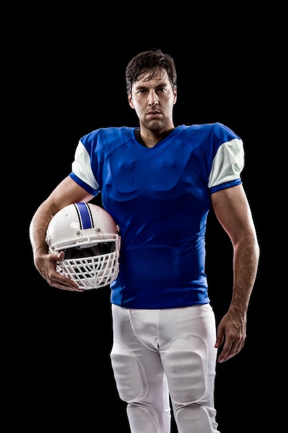 Football Player with a blue uniform on a black wall