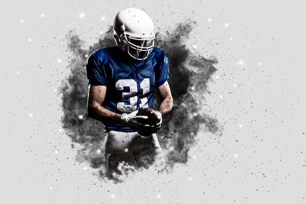 Football Player with a Blue uniform coming out of a blast of smoke .