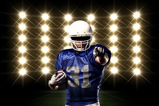 Football Player with a Blue uniform in front of lights