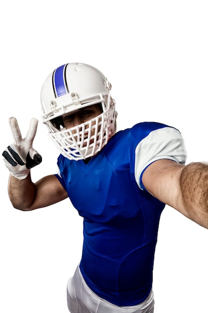 Football Player with a blue uniform making a selfie on a white wall