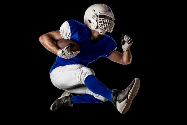 Foto giocatore di football americano con una divisa blu in esecuzione su un muro nero