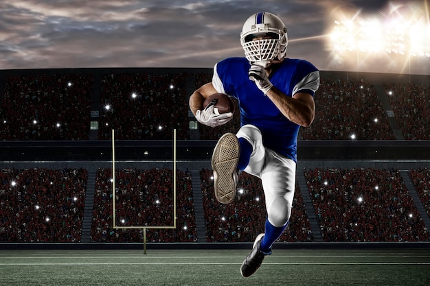 Football Player with a blue uniform running on a stadium