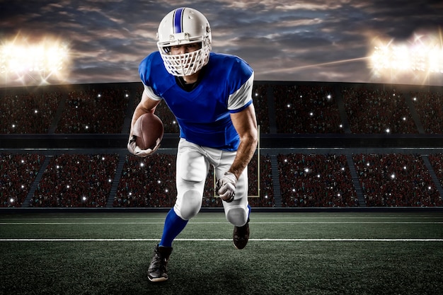 Football Player with a blue uniform running on a stadium