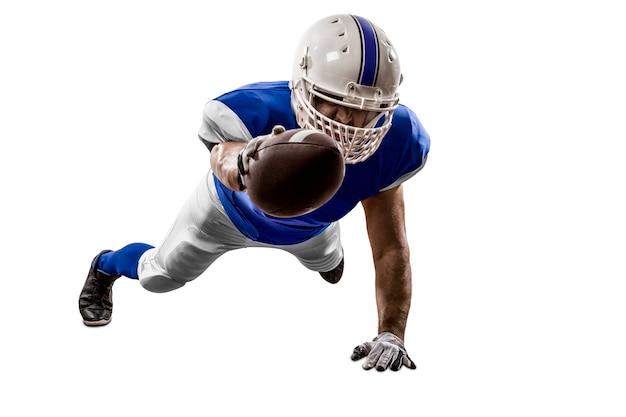 Photo football player with a blue uniform scoring on a white wall