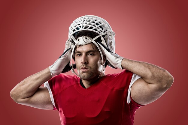 Football Player with a red uniform on a red wall