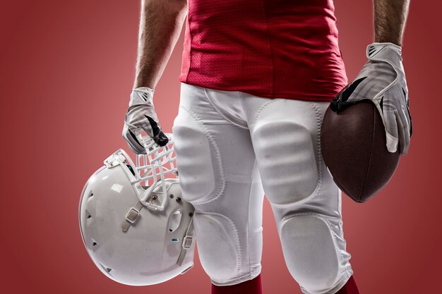 Football Player with a red uniform on a red wall