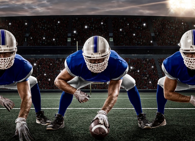 Football Players with a blue uniform on the scrimmage line, on a stadium