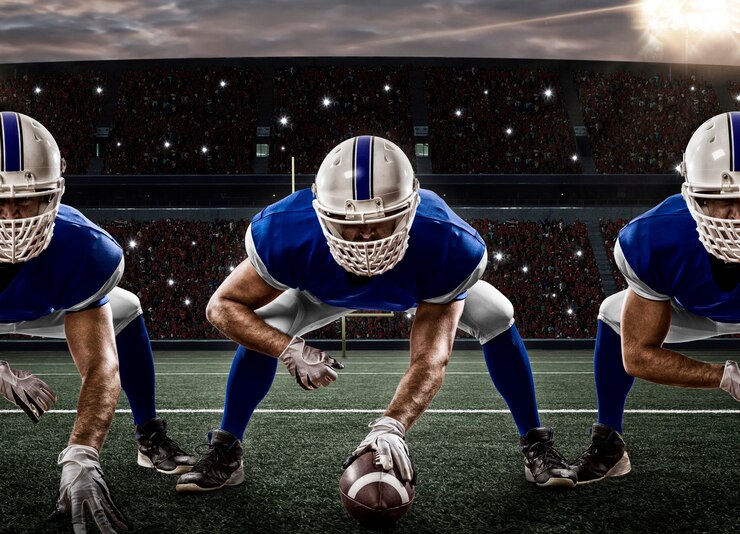 Photo football players with a blue uniform on the scrimmage line, on a stadium