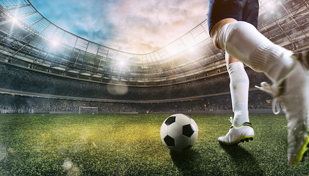 Футбольная сцена на стадионе с крупным планом футбольной обуви, бьющей по мячу