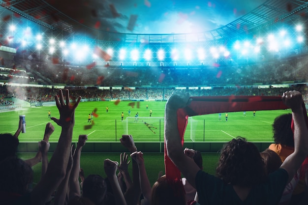football scene at night match with cheering fans at the stadium