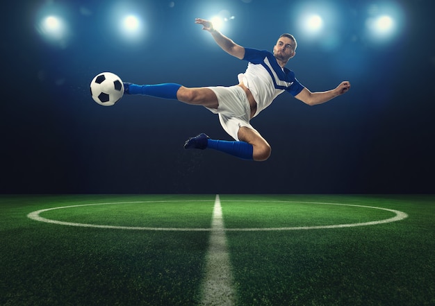 Photo football scene with a player who kicks the ball on the fly at the stadium