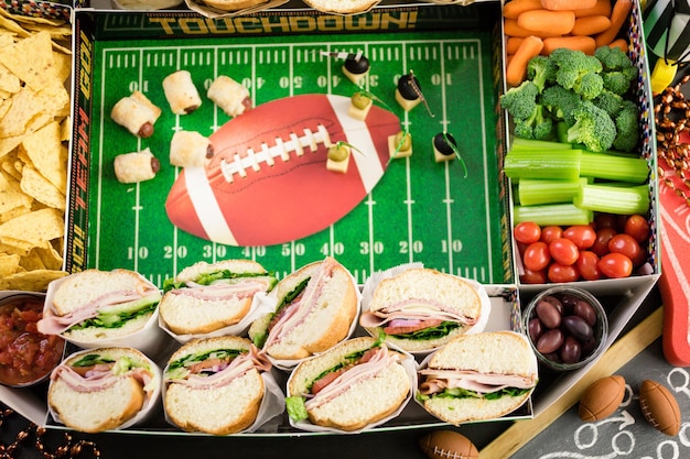 Football Snack Stadium gevuld met sub sandwiches, veggies en chips.