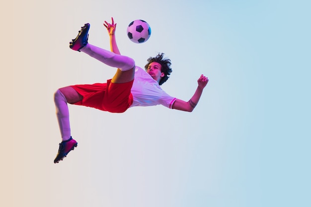 Football or soccer player on gradient background in neon light  motion action activity concept