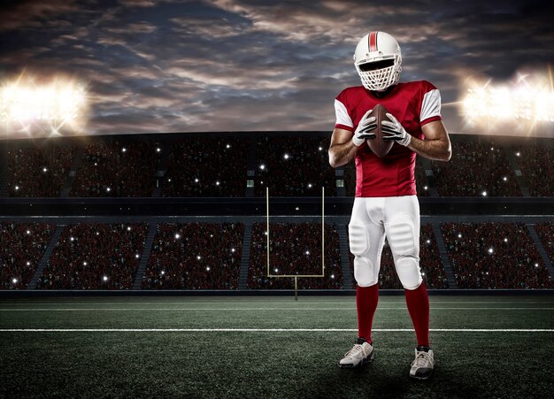 Football-speler met een rood uniform op een stadion.