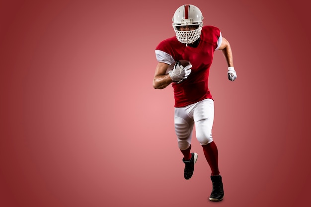 Football-speler met een rood uniform uitgevoerd op een rode muur