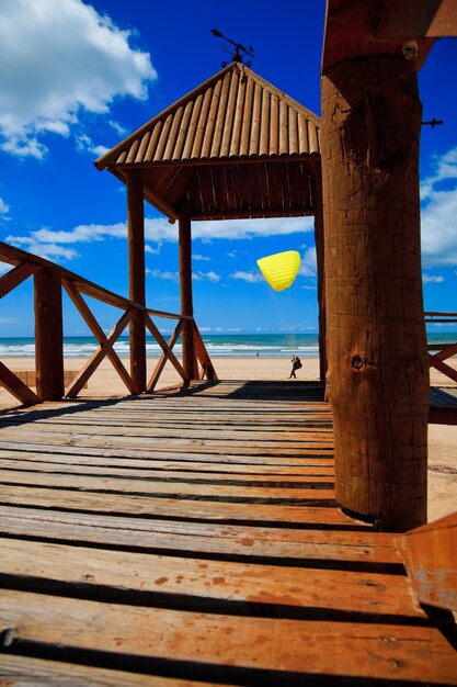 Footbridge of access to Cortadura's beach in Cádiz and paraglider