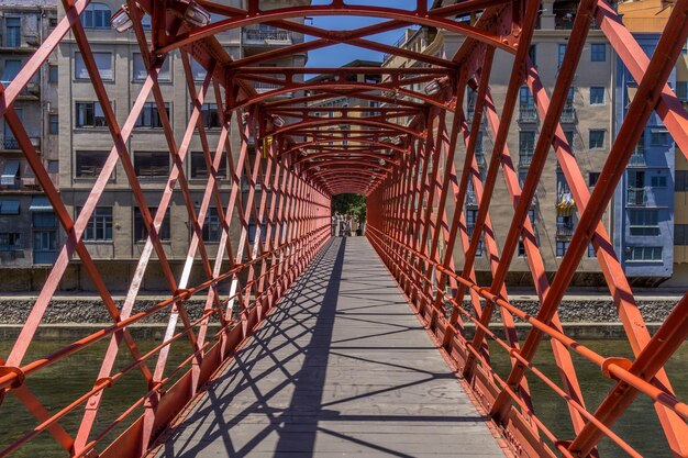 Footbridge in city against sky