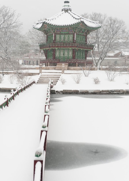 Foto ponte pedonale coperto di neve che conduce verso il tempio cinese