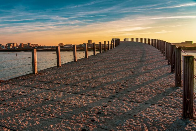 A footbridge in the dutch city of nijmegen at sunset