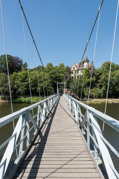 Foto ponte pedonale sul fiume contro un cielo blu limpido