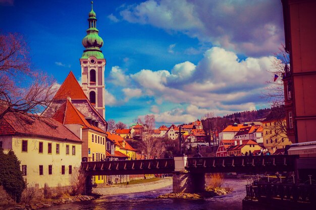 Footbridge over river in town against sky