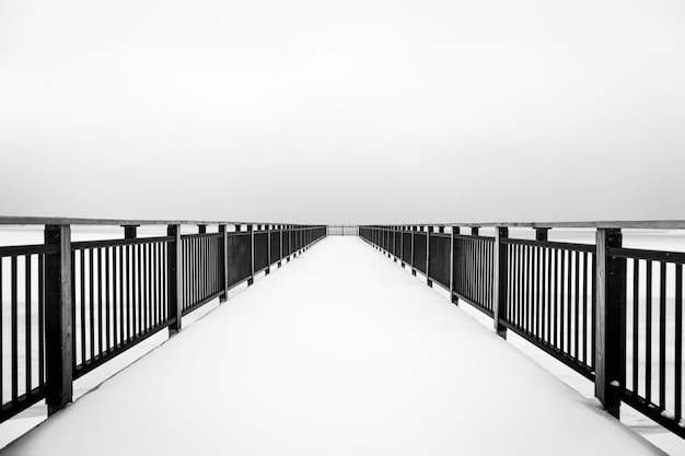 footbridge over sea against clear sky