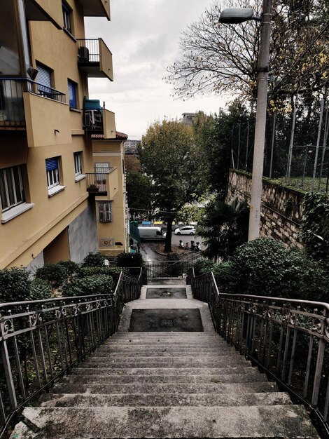 Footpath amidst buildings against sky