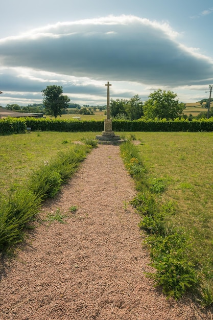 Photo footpath amidst cemetery against sky