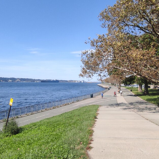 Footpath by sea against sky